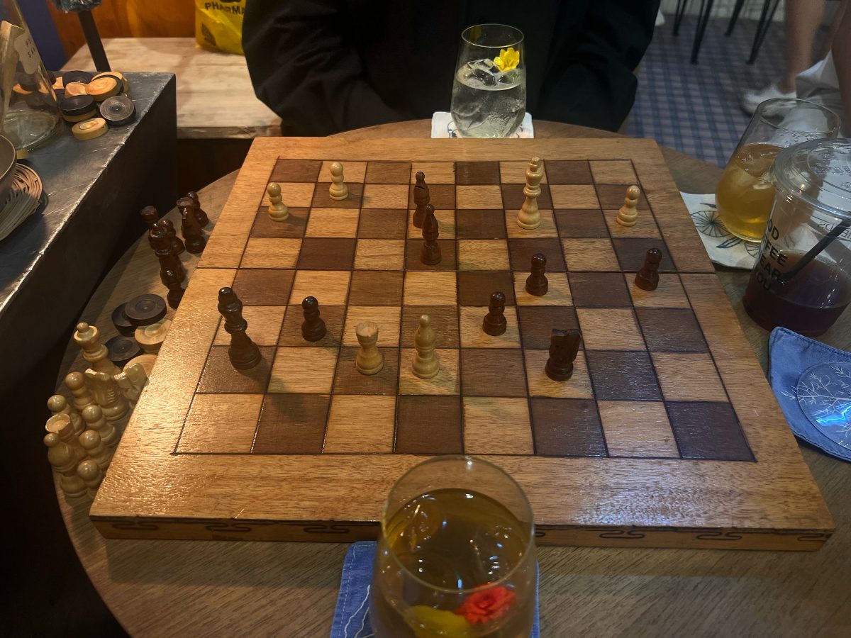 A wooden chessboard on a bar table